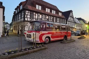 Bus vor einem Fachwerkhaus