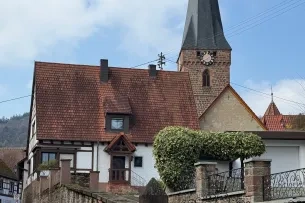 Haus mit Kirchturm im Hintergrund