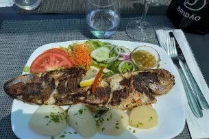 Zwei gebratene Fische mit Salat und Kartoffeln