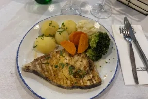 Ein Teller mit Fisch, Kartoffeln und Gemüse